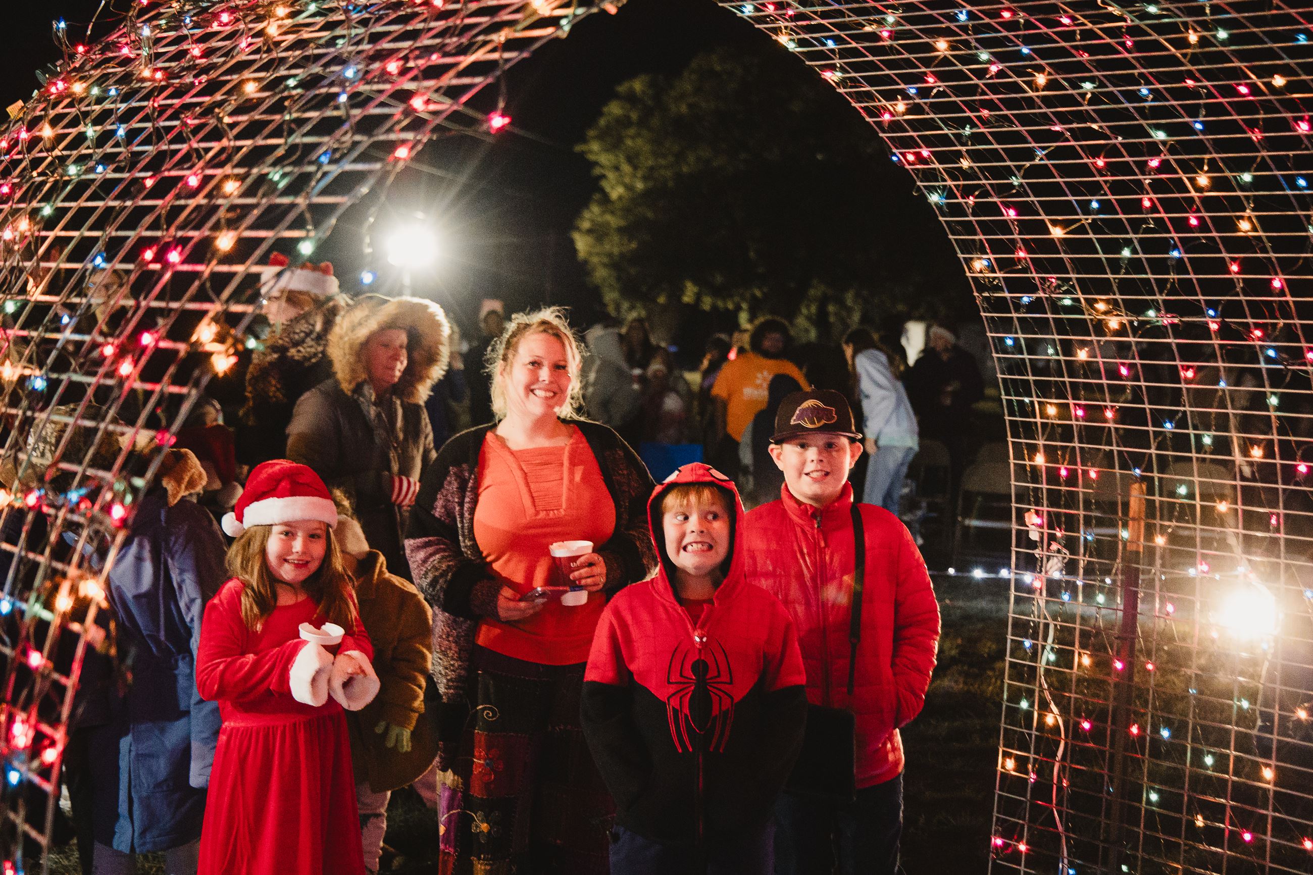 Picture of a family under a lighted Christmas tunnel
